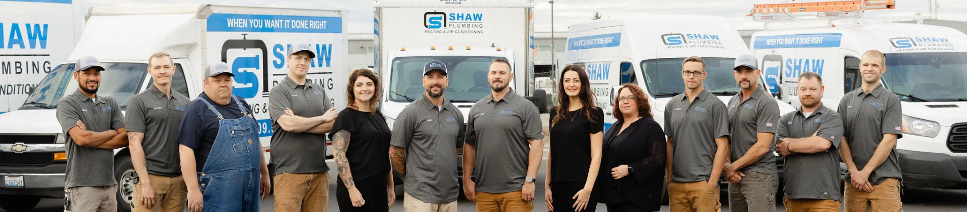 The Shaw Plumbing team lined up in front of their service trucks